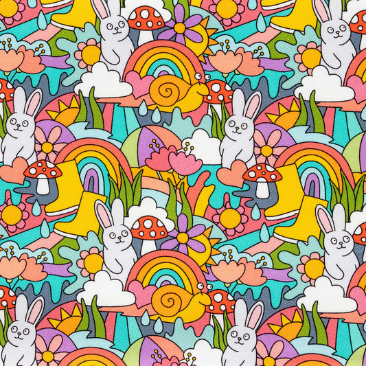 The Some Bunny Loves You Stretch Twill Fabric laid flat. The colourful stretch cotton fabric features smiling white bunnies, red toadstool mushrooms, umbrellas, rainbows, sunshines, rainclouds, raindrops, snails, hearts, grass and flowers.
