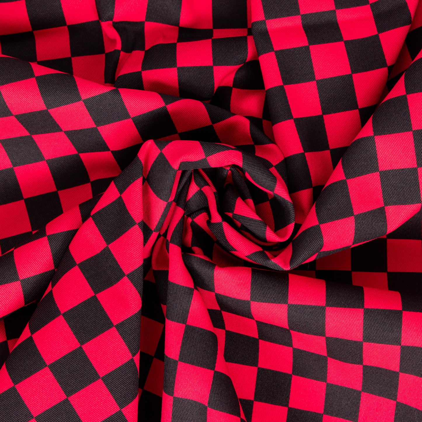 The Black & Viva Magenta Checkerboard Stretch Twill Fabric swirled and folded into the centre. The red and black checker print fabric is digitally printed and is stretch cotton.