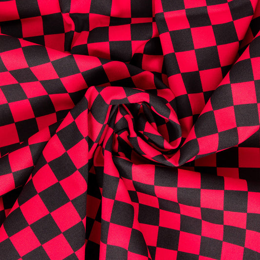 The Black & Viva Magenta Checkerboard Stretch Twill Fabric swirled and folded into the centre. The red and black checker print fabric is digitally printed and is stretch cotton.