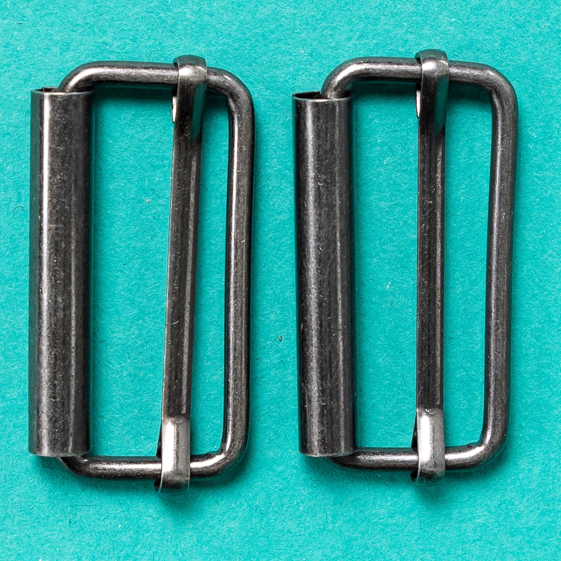 close up of silver buckle fastenings on a green background