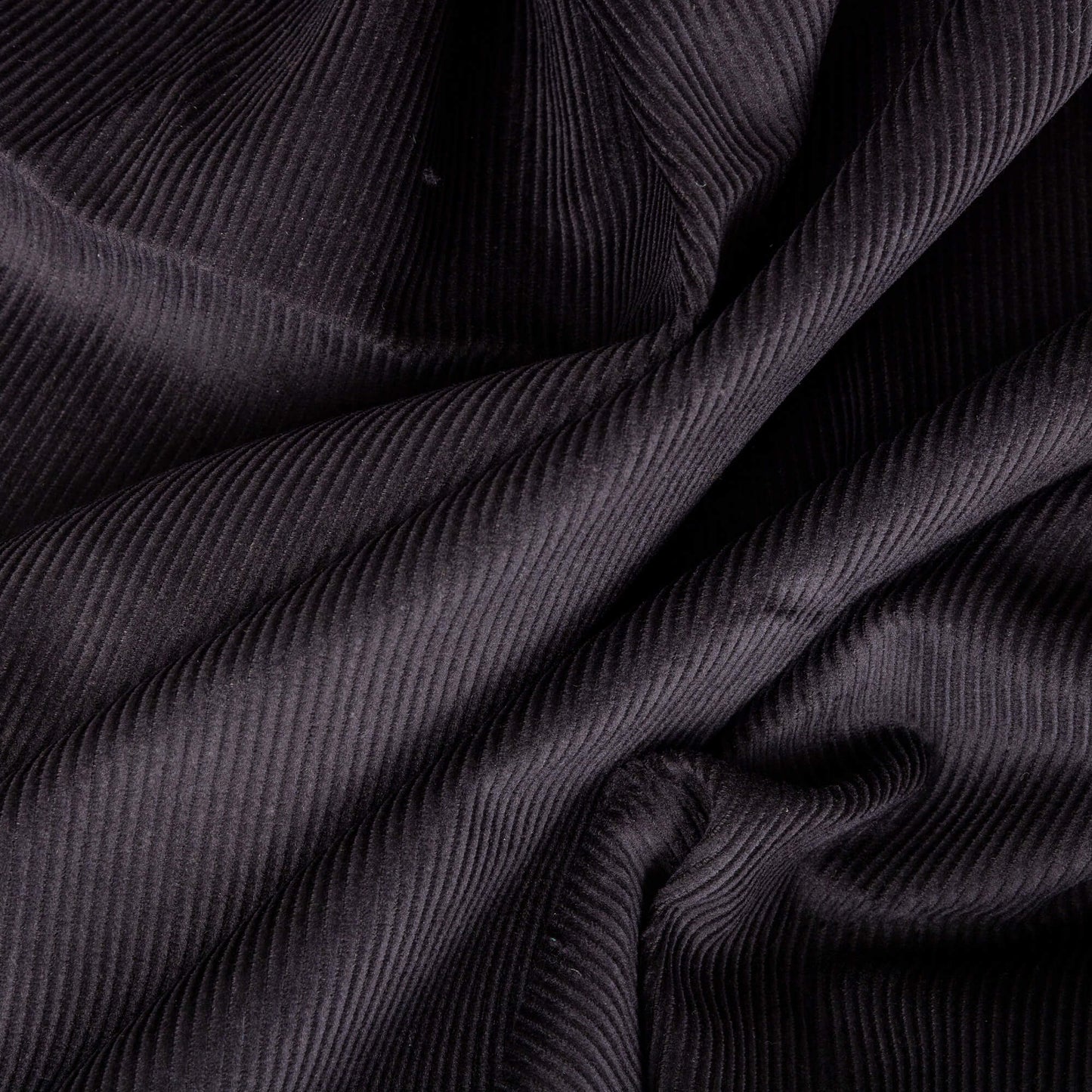 picture of black corduroy fabric, the cord fabric looks like it is in waves and is ready for craft projects