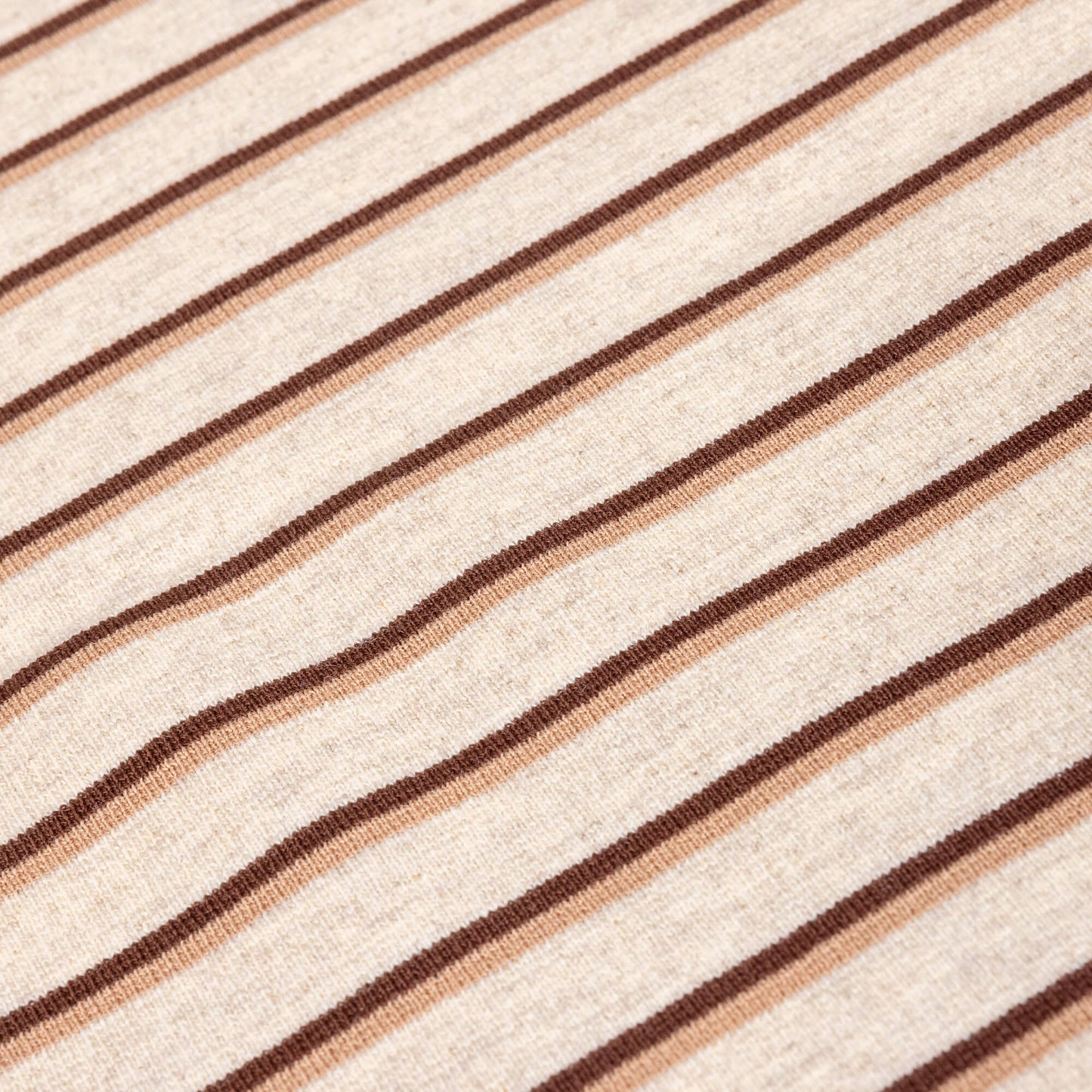 A close up of Ecru, brown and beige striped soft t-shirt material in a jersey fabric for making clothing or crafting projects.