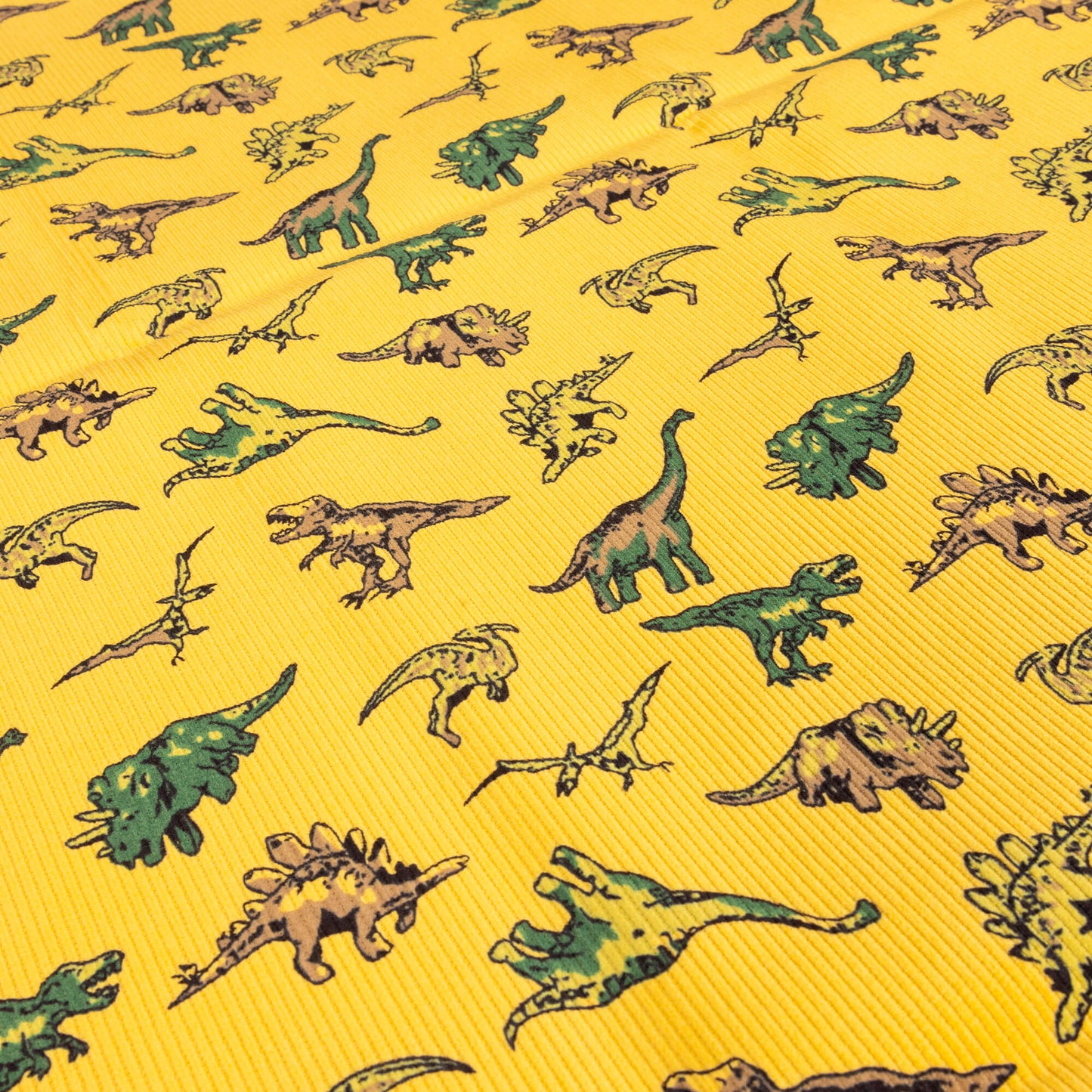 A wide image stretch gold mustard coloured dinosaur corduroy fabric with different dinos great for children's clothing, sewing and homeware projects
