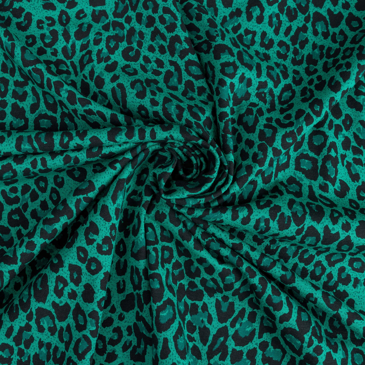 A swirl of green and black leopard print stretch jersey fabric for making clothing and craft projects
