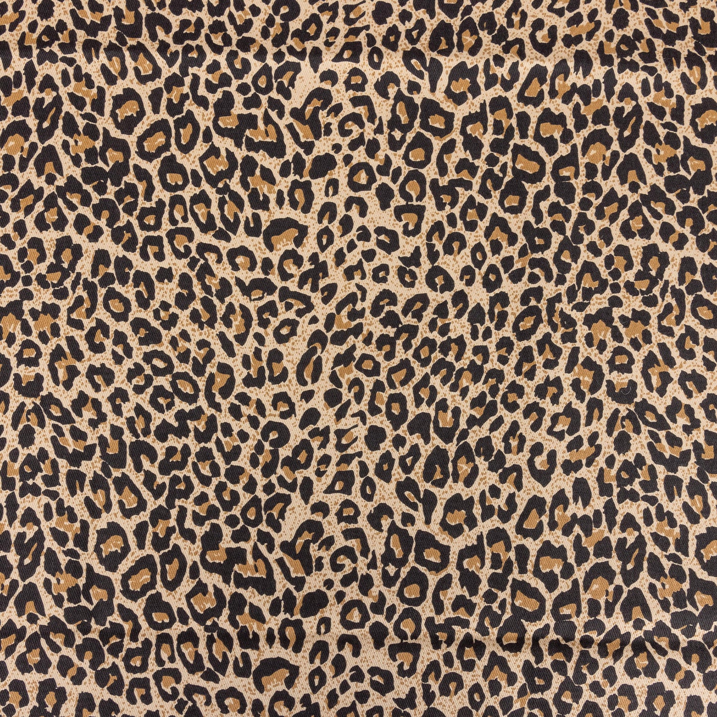 A close up of brown leopard print fabric with black, beige and a soft beige background the tones are warm