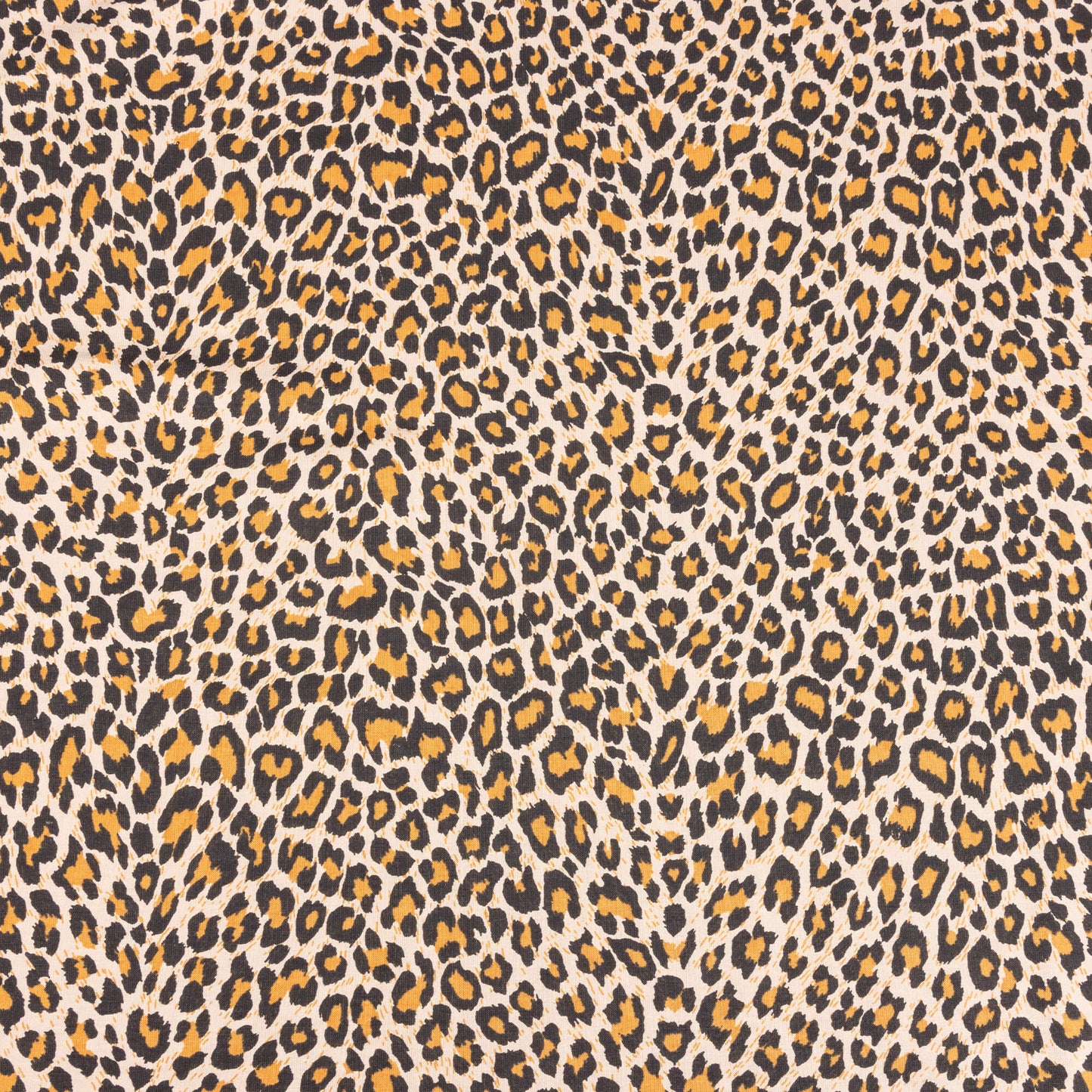 A wide look at the natural leopard print fabric with orange, beige and black to form the leopard spots on a sand background