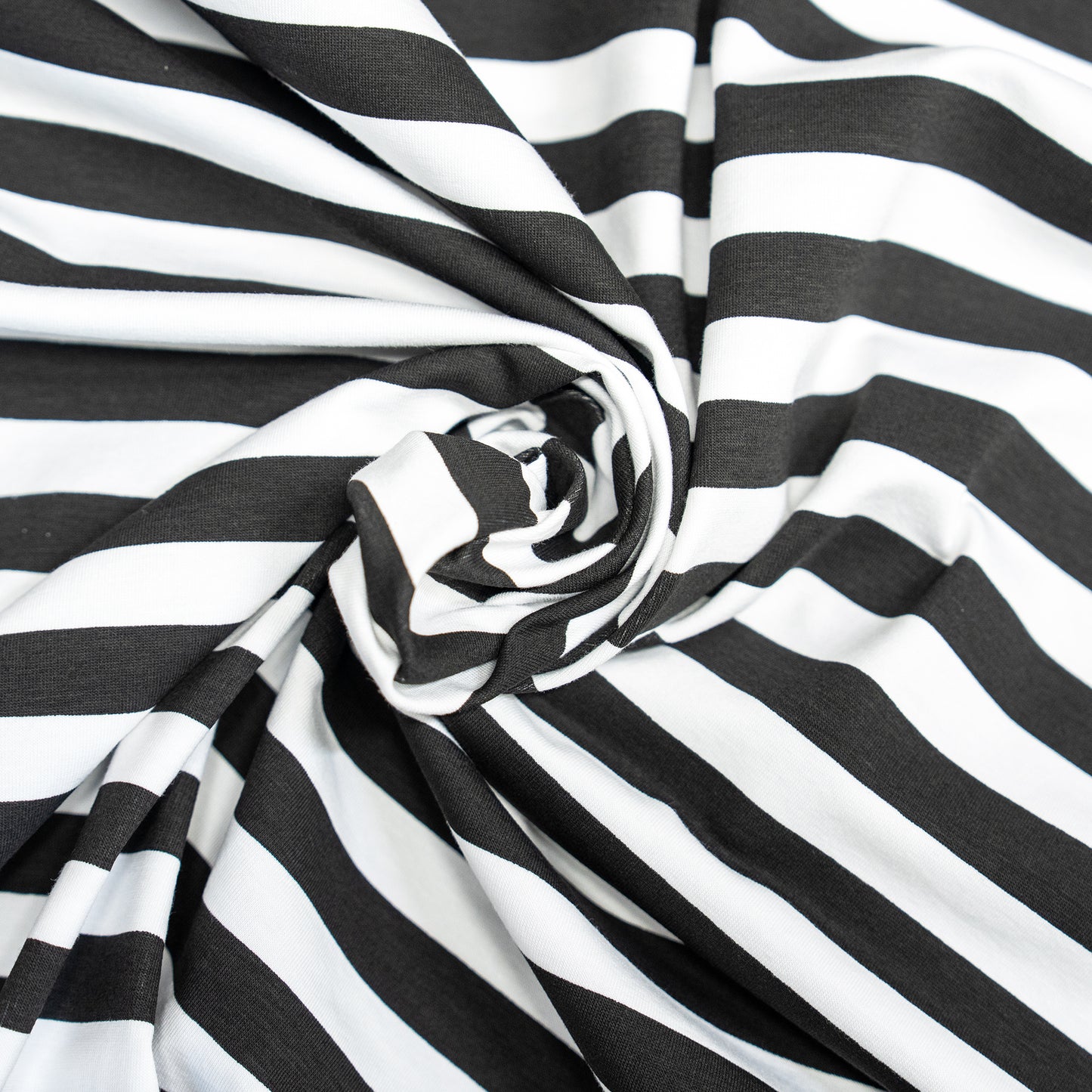Swirled black and white 1.5cm stripe jersey fabric from Brunswick Mills, soft and stretchy—ideal for T-shirts and casual wear.