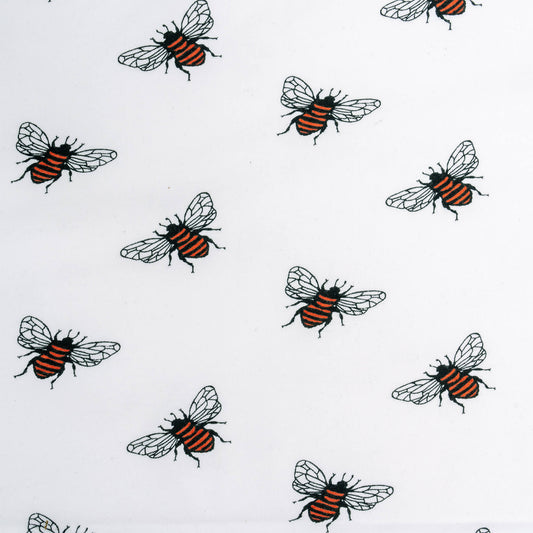 White fabric displaying a repeating bee pattern. Each bee has a black and orange striped body with finely detailed transparent wings. The bees are evenly distributed across the fabric, creating a consistent and charming design.