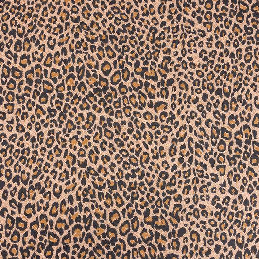 A wide look at the brown leopard print single jersey t-shirt fabric with orange, beige and black to form the leopard spots on a sand background