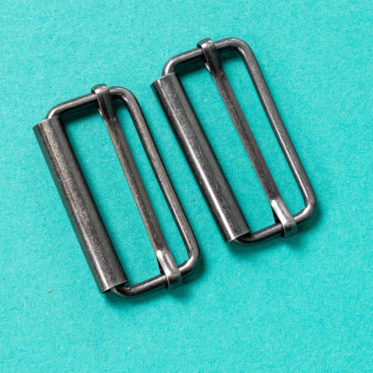 close up of silver buckle fastenings on a green background