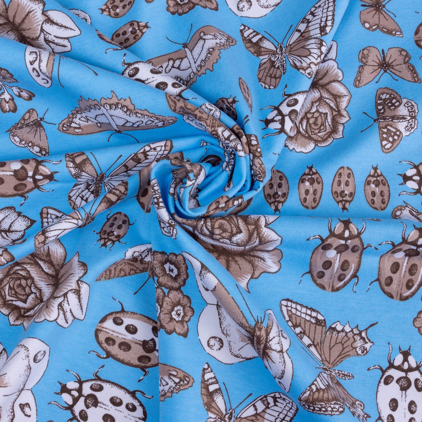 A swirl of stretch jersey fabric featuring sketches of beetles, butterflies, florals and bugs on a light blue bright background