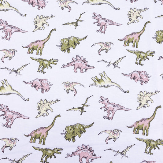 A wide look at the white dinosaur stretch jersey fabric with different dinosaurs on in pale greens, pinks and yellows.