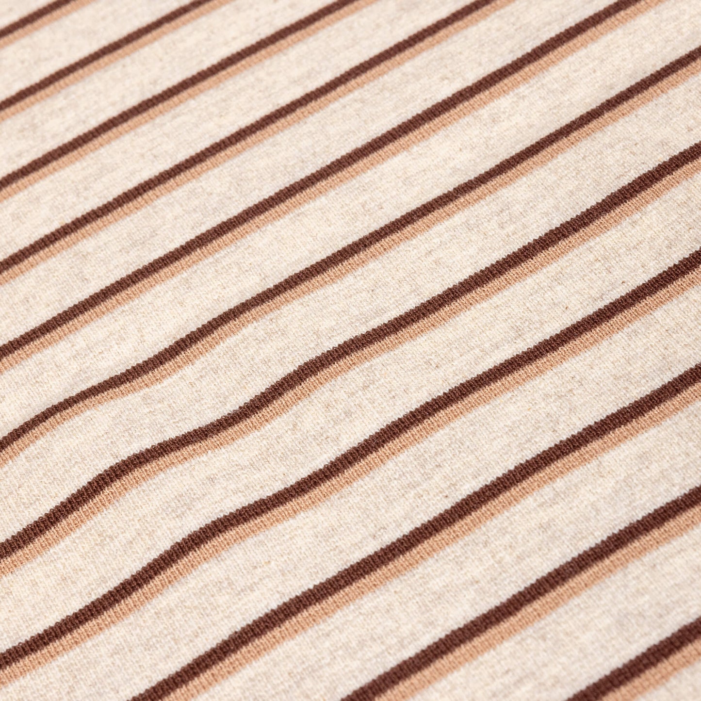 A close up of Ecru, brown and beige striped  soft t-shirt material in a jersey fabric for making clothing or crafting projects.