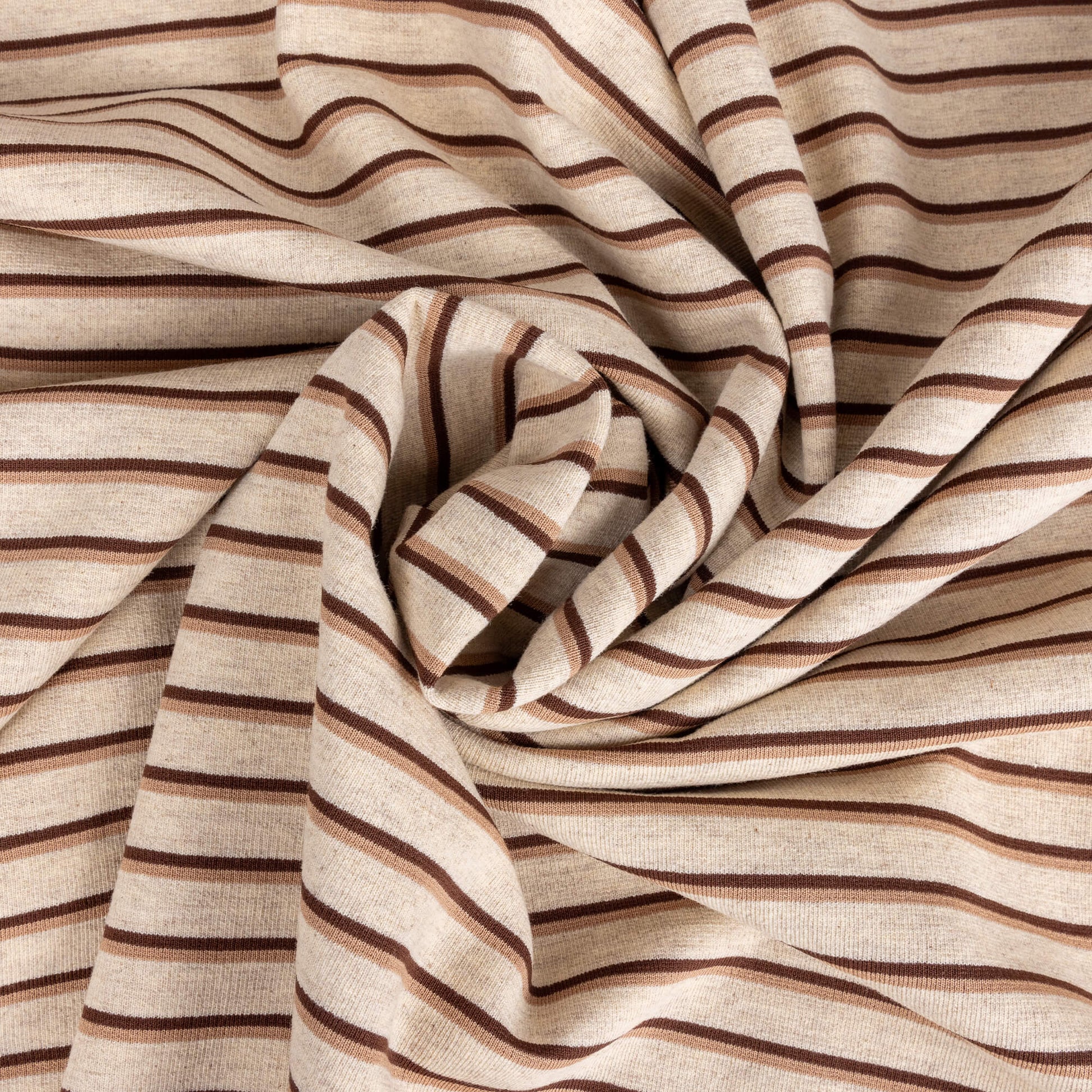 A messy ball of Ecru, brown and beige striped soft t-shirt material in a jersey fabric for making clothing or crafting projects.