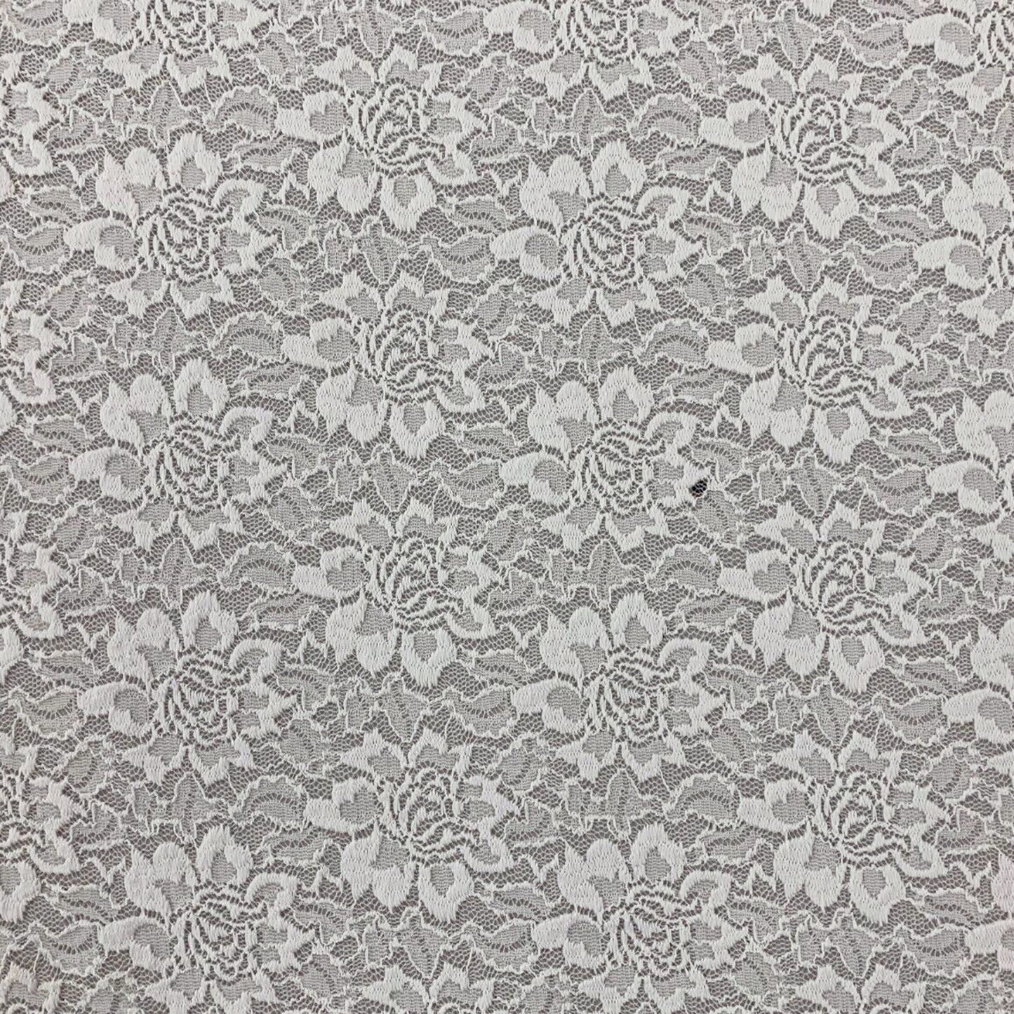 Ivory white floral stretch lace fabric for sewing and clothing projects shown on a black base to show off the flowers 