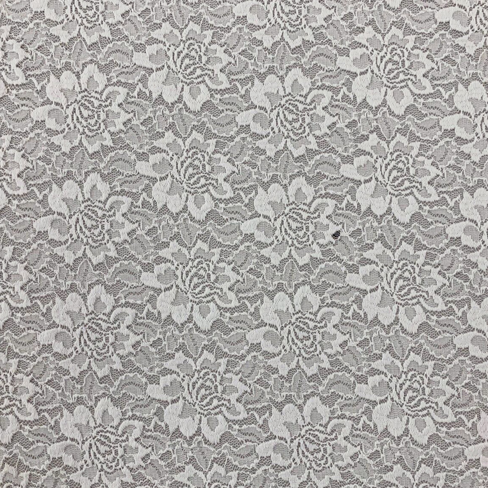 Ivory white floral stretch lace fabric for sewing and clothing projects shown on a black base to show off the flowers 