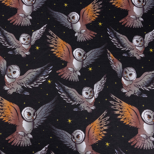 A look at the What a hoot stretch jersey fabric featuring barn owls in flight with black background and yellow twinkly stars