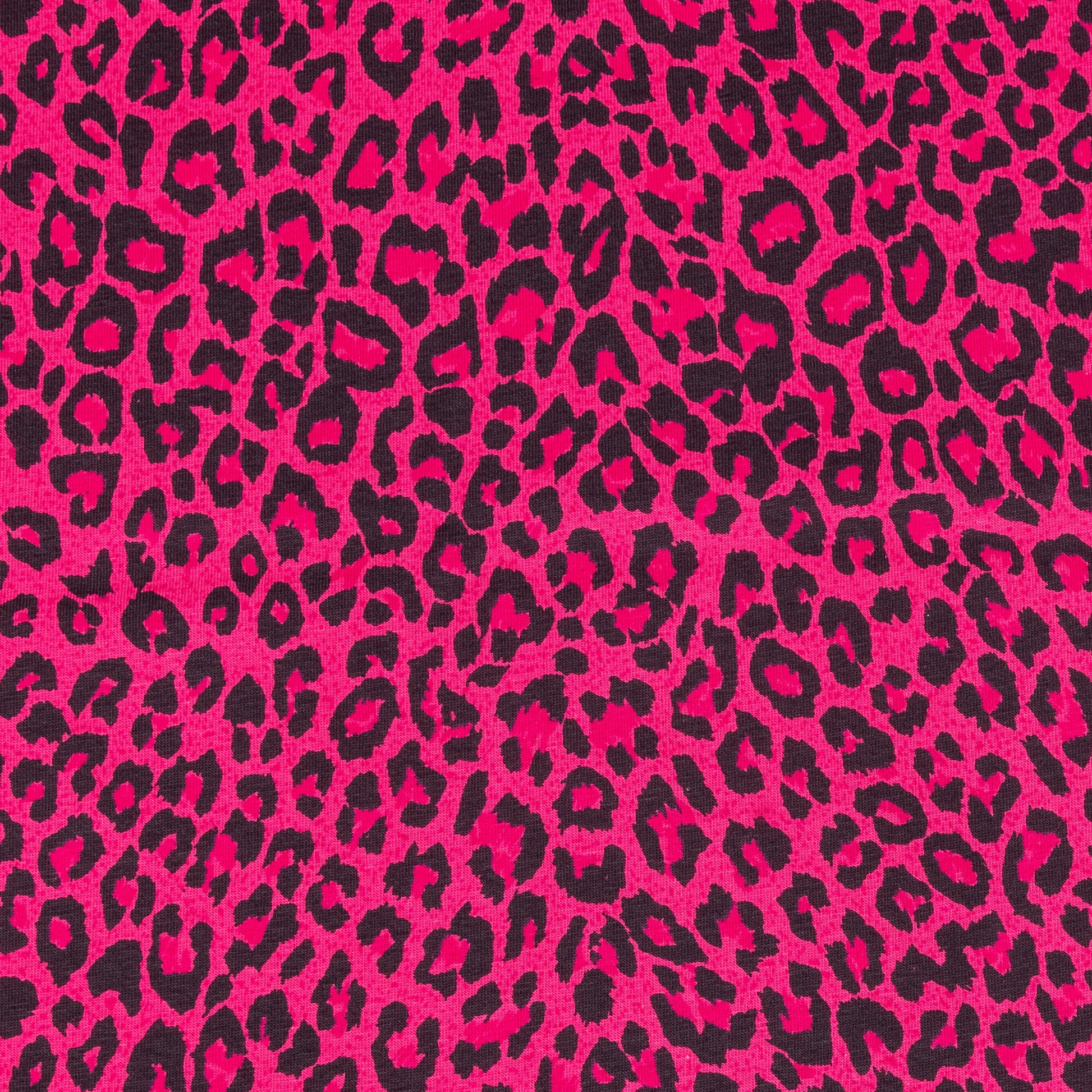 A close up of bright pink and black leopard print fabric in a soft jersey t-shirt weight perfect for crafting