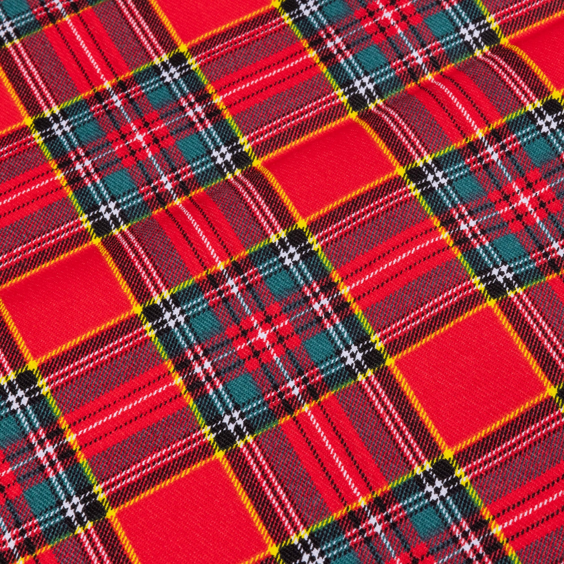 A close up of Red tartan fabric  showing yellow, white, green and navy against a red background