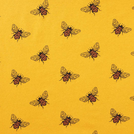 close up of mustard gold coloured fabric showing bees with black and orange stripes and delicate wings