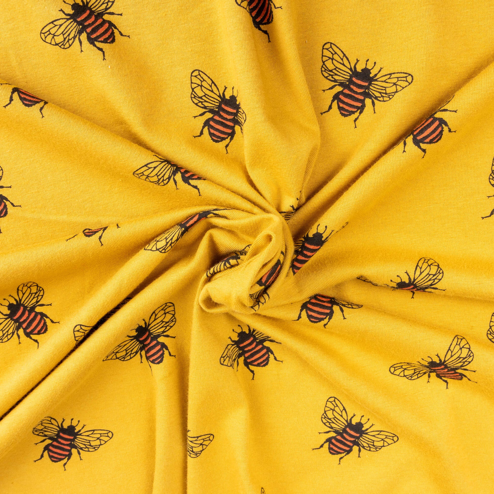 close up a twisted portion of mustard gold coloured fabric showing bees with black and orange stripes and delicate wings